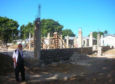 Baba Fulgenzio davanti al cantiere delle Scuole Secondarie in costruzione